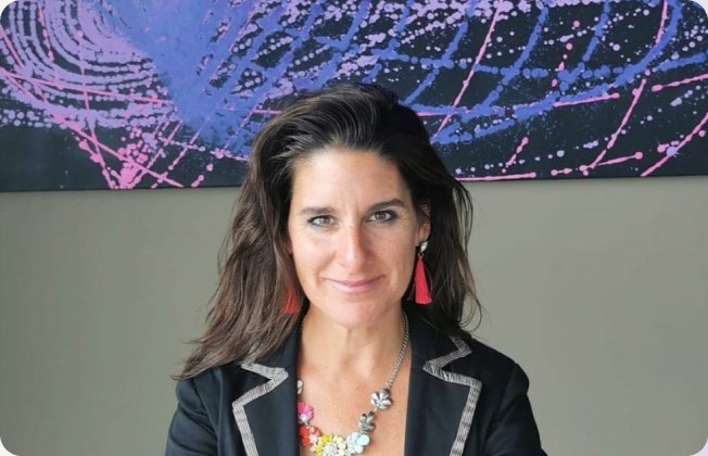April Popko in front of one of her paintings
